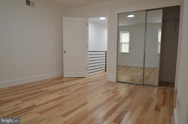 unfurnished bedroom with a closet and light wood-type flooring