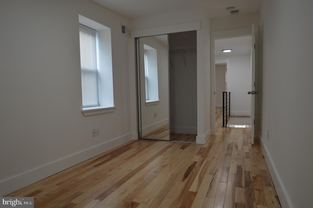 unfurnished bedroom featuring a closet and light wood-type flooring