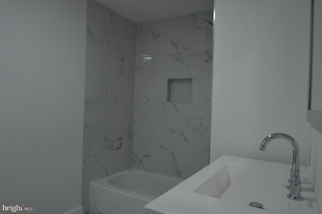 bathroom featuring sink and tiled shower / bath