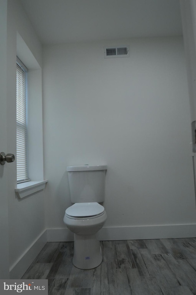 bathroom with wood-type flooring and toilet