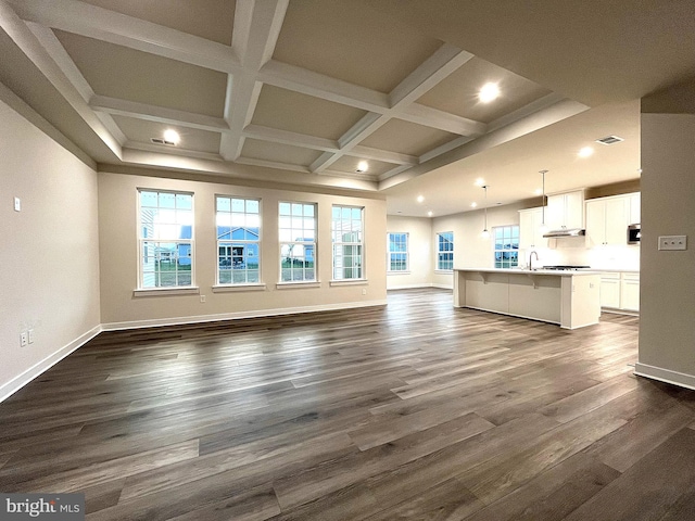 unfurnished living room with beamed ceiling, dark wood-type flooring, and coffered ceiling