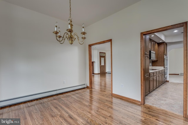 unfurnished room with a baseboard radiator, a notable chandelier, and light hardwood / wood-style flooring