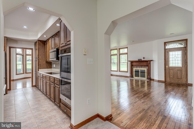 kitchen with light hardwood / wood-style flooring, stainless steel appliances, and tasteful backsplash