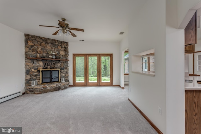 unfurnished living room featuring light carpet, a baseboard radiator, a fireplace, and ceiling fan