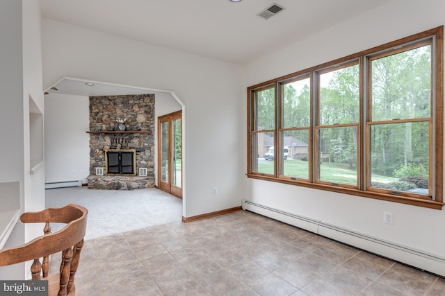 unfurnished living room with a baseboard radiator, a fireplace, and plenty of natural light