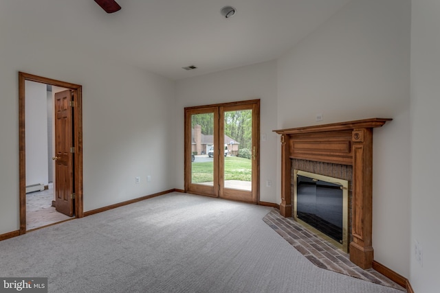 unfurnished living room with light carpet, a baseboard heating unit, a fireplace, and ceiling fan