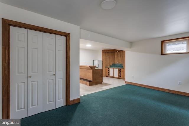 basement with light carpet and white fridge