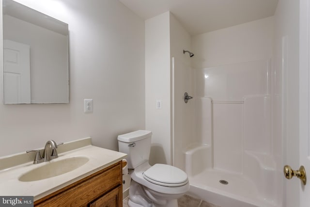 bathroom featuring toilet, walk in shower, vanity, and tile patterned flooring