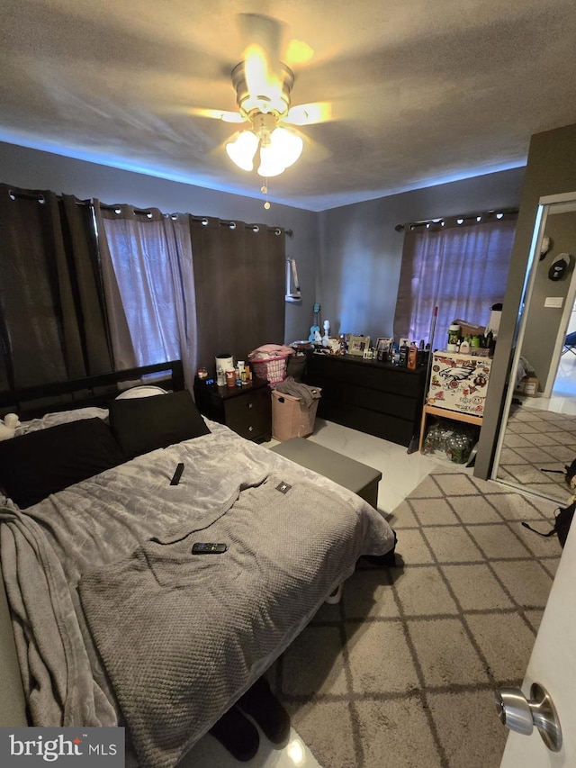 bedroom with carpet floors, a textured ceiling, and ceiling fan