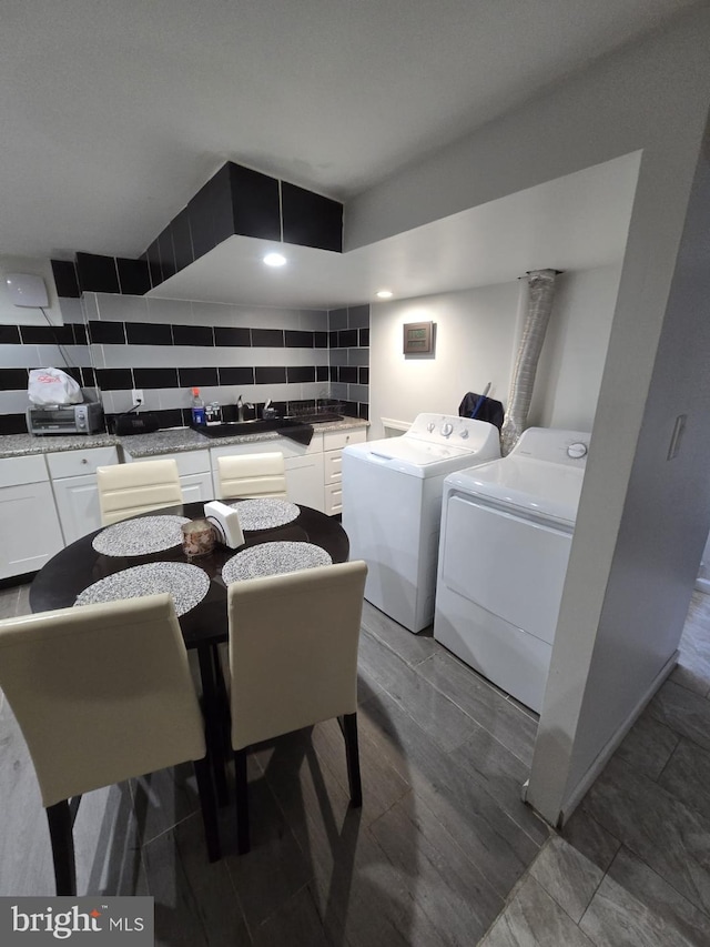 laundry area with washer and dryer, hardwood / wood-style flooring, and sink