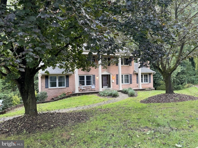 view of front of property featuring a front yard and brick siding