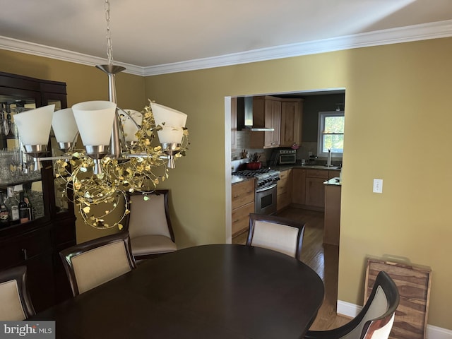 dining area with hardwood / wood-style flooring, ornamental molding, and sink