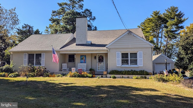 view of front of house featuring a garage, an outdoor structure, and a front lawn