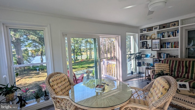 dining space with crown molding, ceiling fan, hardwood / wood-style floors, and a healthy amount of sunlight