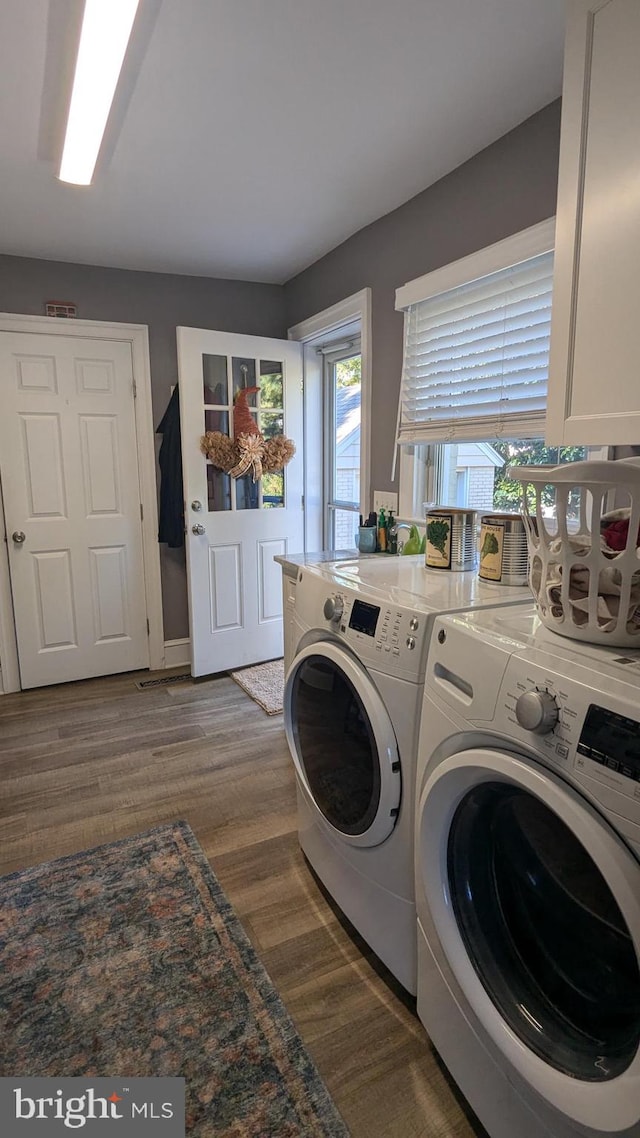 laundry room with separate washer and dryer and dark wood-type flooring