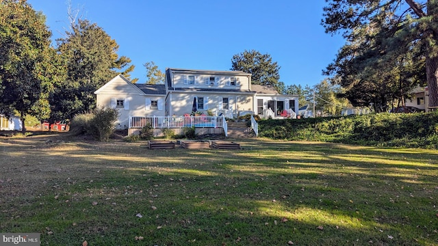 rear view of house with a lawn and a wooden deck