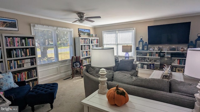 carpeted living room featuring ceiling fan and ornamental molding