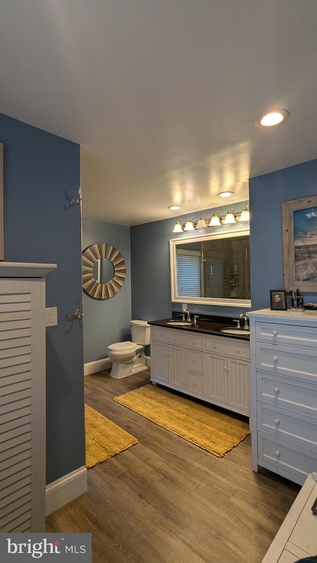 bathroom with hardwood / wood-style flooring, vanity, and toilet