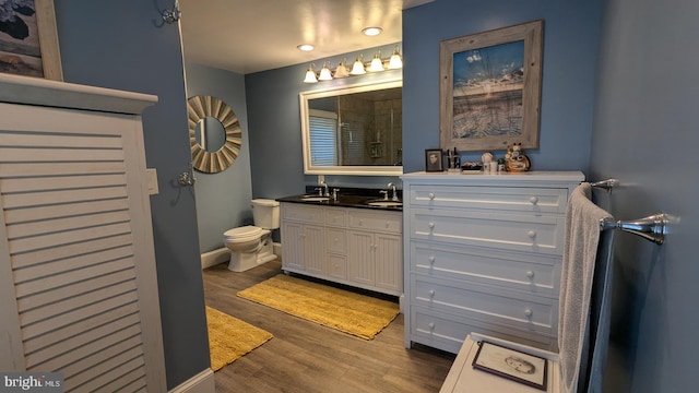 bathroom featuring toilet, vanity, and hardwood / wood-style flooring