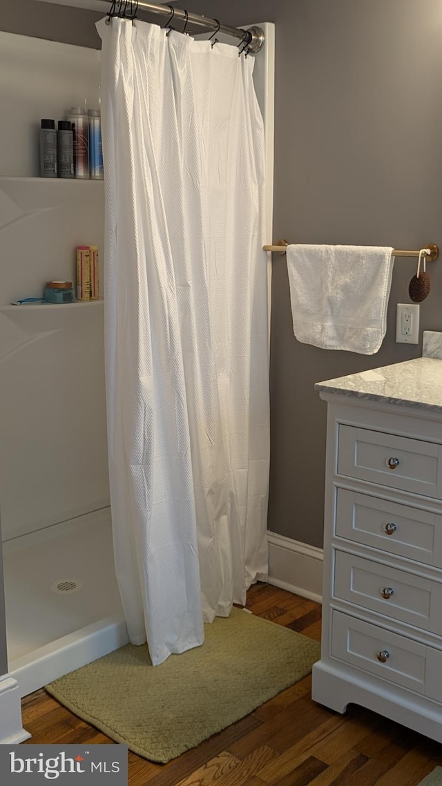 bathroom featuring hardwood / wood-style floors, vanity, and a shower with shower curtain