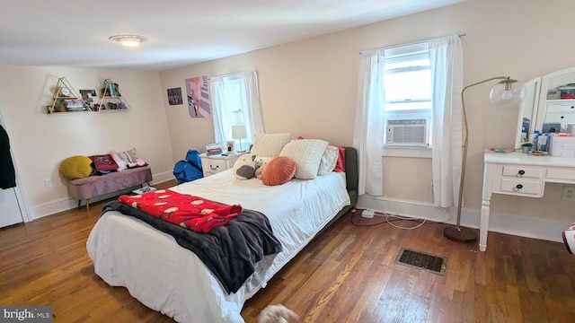 bedroom featuring cooling unit and dark wood-type flooring