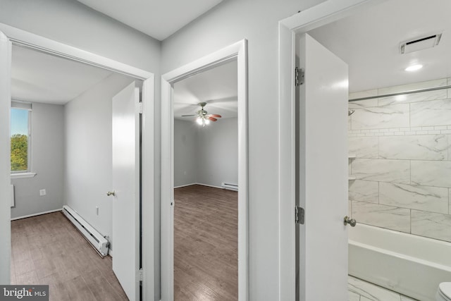 hall featuring baseboard heating and hardwood / wood-style flooring