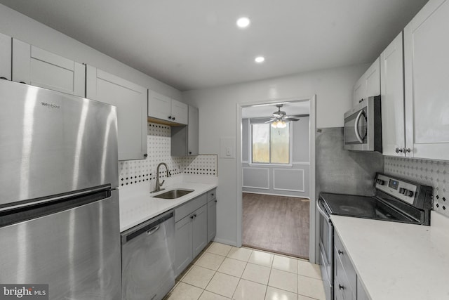 kitchen with tasteful backsplash, light tile patterned floors, sink, gray cabinets, and stainless steel appliances