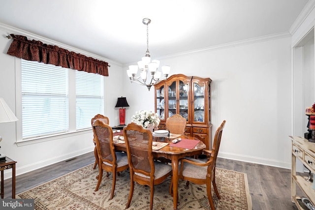 dining space featuring dark hardwood / wood-style flooring, crown molding, and a chandelier