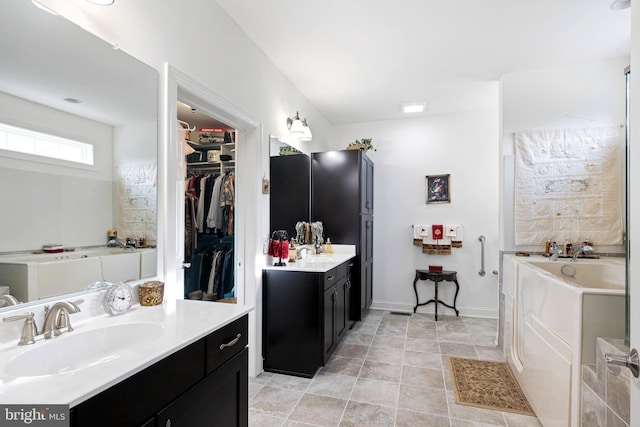 bathroom featuring a bathing tub, vanity, and tile patterned flooring