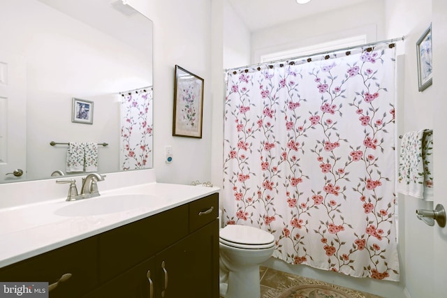 bathroom featuring tile patterned floors, vanity, toilet, and walk in shower