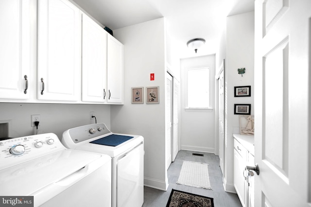 washroom with washing machine and dryer and cabinets