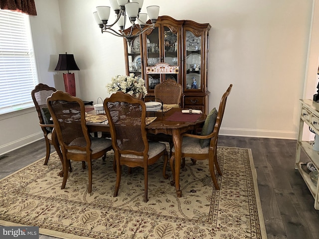 dining room featuring dark hardwood / wood-style flooring and an inviting chandelier