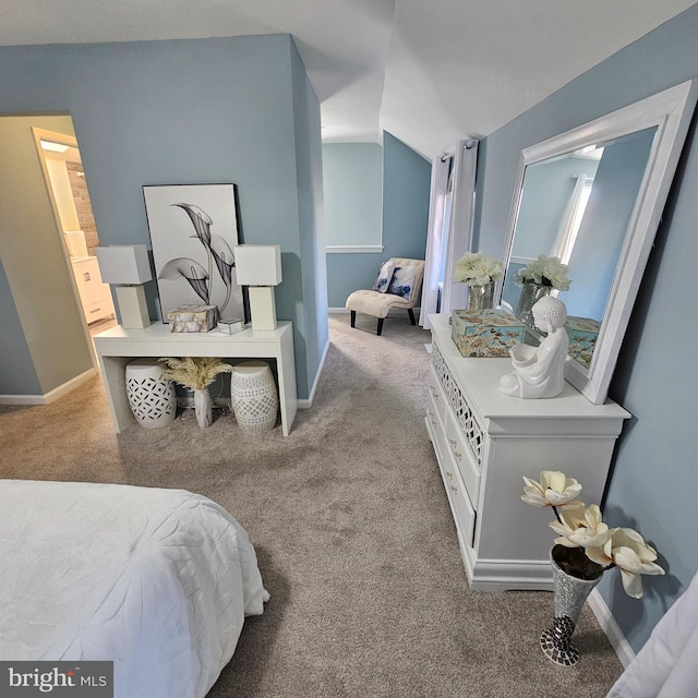 bedroom featuring ensuite bath, carpet flooring, and vaulted ceiling