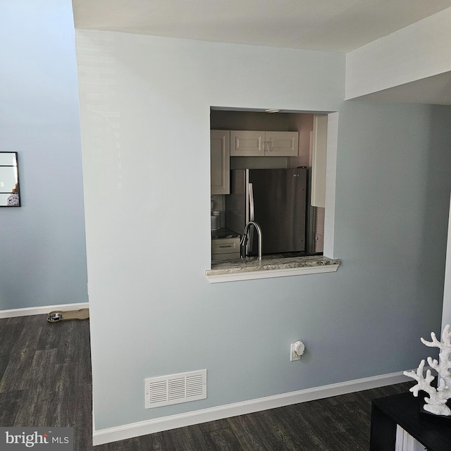 details featuring stainless steel fridge, hardwood / wood-style flooring, and sink