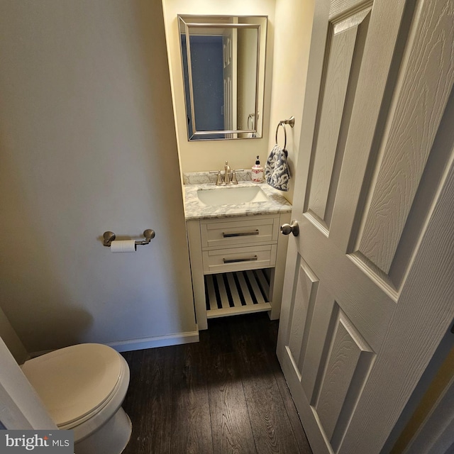 bathroom featuring vanity, toilet, and hardwood / wood-style flooring