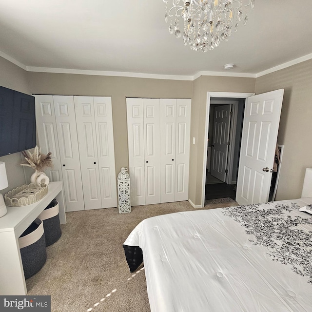 bedroom featuring multiple closets, ornamental molding, carpet flooring, and an inviting chandelier