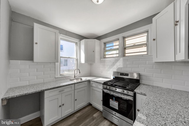 kitchen featuring stainless steel gas range oven, white cabinetry, dark wood-type flooring, and plenty of natural light