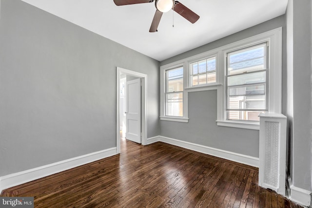 spare room with dark wood-type flooring and ceiling fan