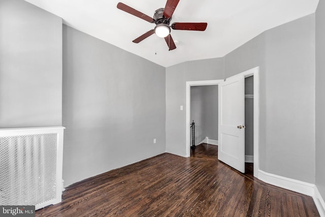 unfurnished bedroom with ceiling fan and dark hardwood / wood-style flooring