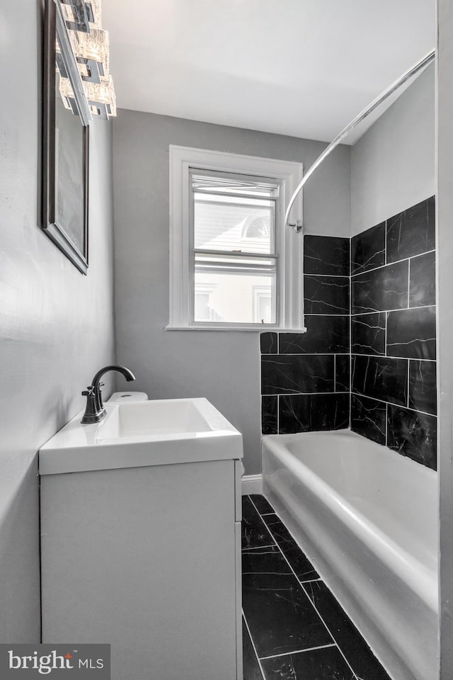 bathroom featuring tiled shower / bath and vanity