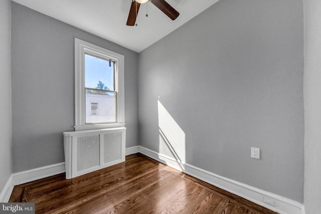 spare room featuring lofted ceiling, radiator heating unit, ceiling fan, and dark hardwood / wood-style flooring