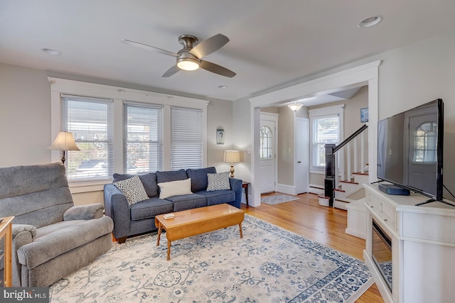 living room with ceiling fan, light hardwood / wood-style flooring, and a baseboard radiator