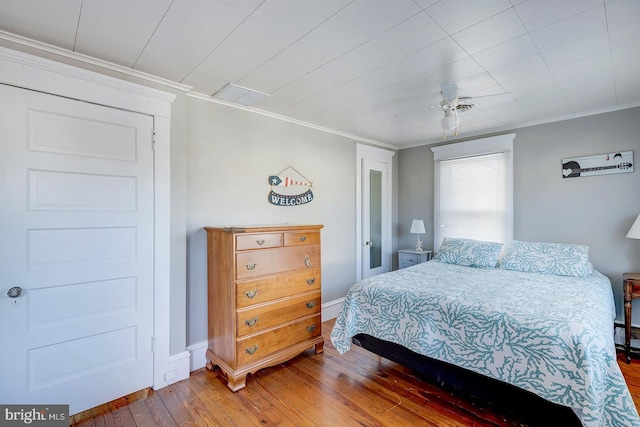 bedroom with hardwood / wood-style floors and crown molding