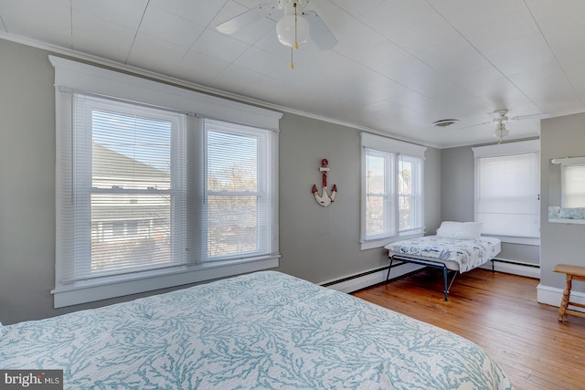 bedroom featuring wood-type flooring, ceiling fan, crown molding, and a baseboard radiator