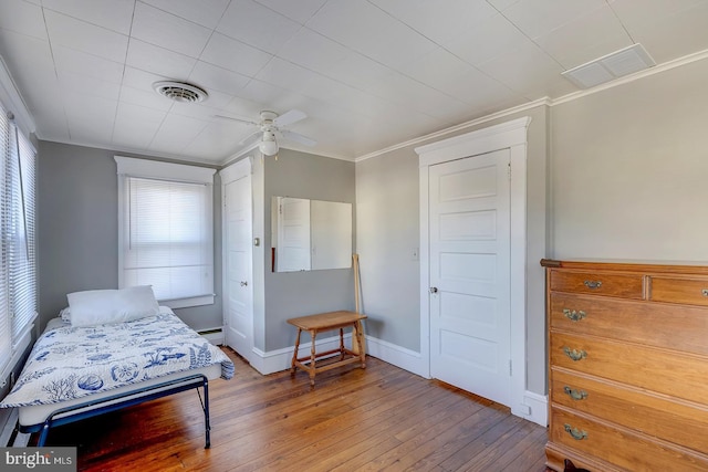 bedroom featuring hardwood / wood-style flooring, ornamental molding, and ceiling fan