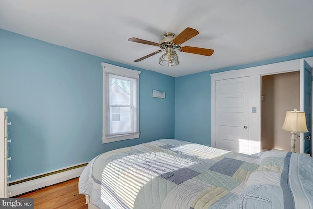 bedroom featuring baseboard heating, ceiling fan, and wood-type flooring