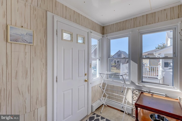 tiled entrance foyer featuring crown molding, plenty of natural light, and a baseboard radiator