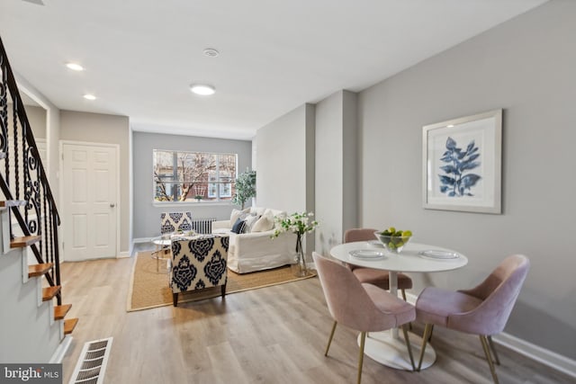 dining area with light hardwood / wood-style floors and radiator heating unit