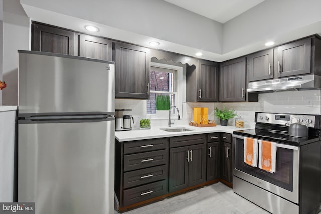 kitchen featuring dark brown cabinetry, sink, stainless steel appliances, tasteful backsplash, and light tile patterned floors