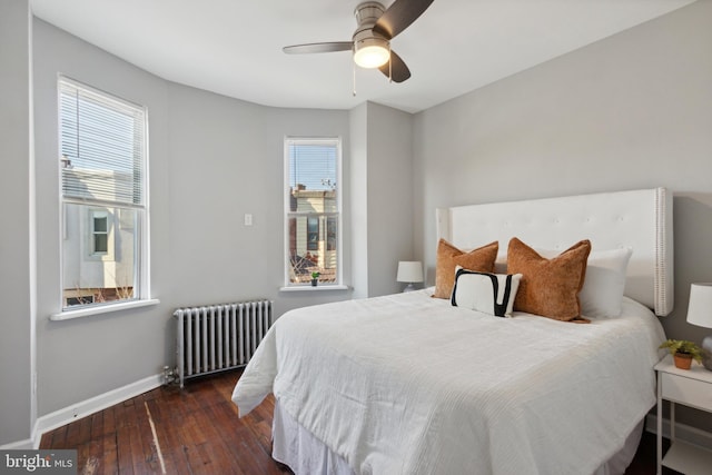 bedroom with ceiling fan, dark wood-type flooring, and radiator